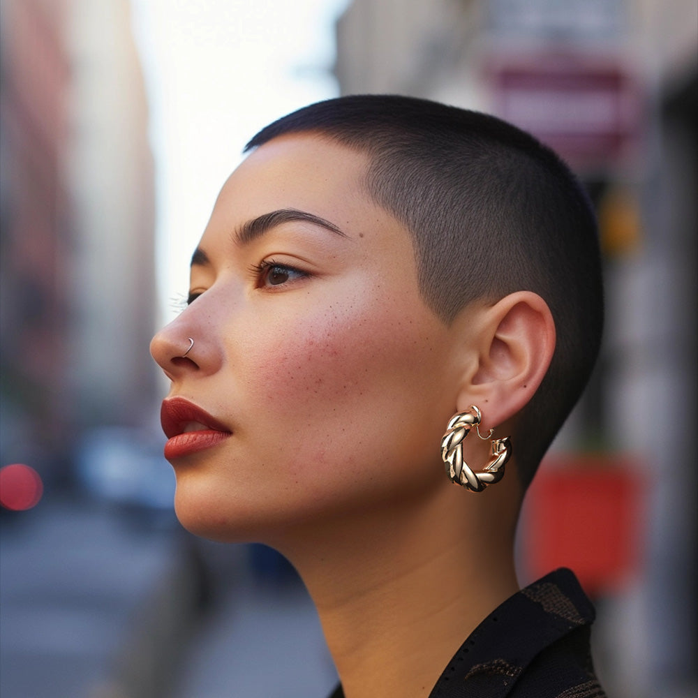 These Bold Twist Hoop Clip-On Earrings present a modern twist on a classic style. In a striking gold color, they are made from a durable alloy with a screw-back clip-on closure for secure wear. The twisted ribbon design adds a sophisticated touch to any look, perfect for those seeking a statement piece without the commitment of pierced ears.