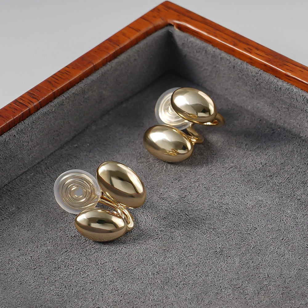 Side angle of Dual Bean-Shaped Clip-On Earrings highlighting the 16k gold plated polished finish.