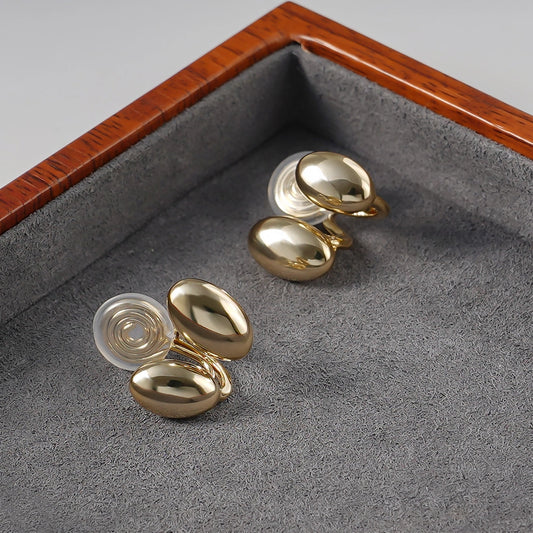 Side angle of Dual Bean-Shaped Clip-On Earrings highlighting the 16k gold plated polished finish.