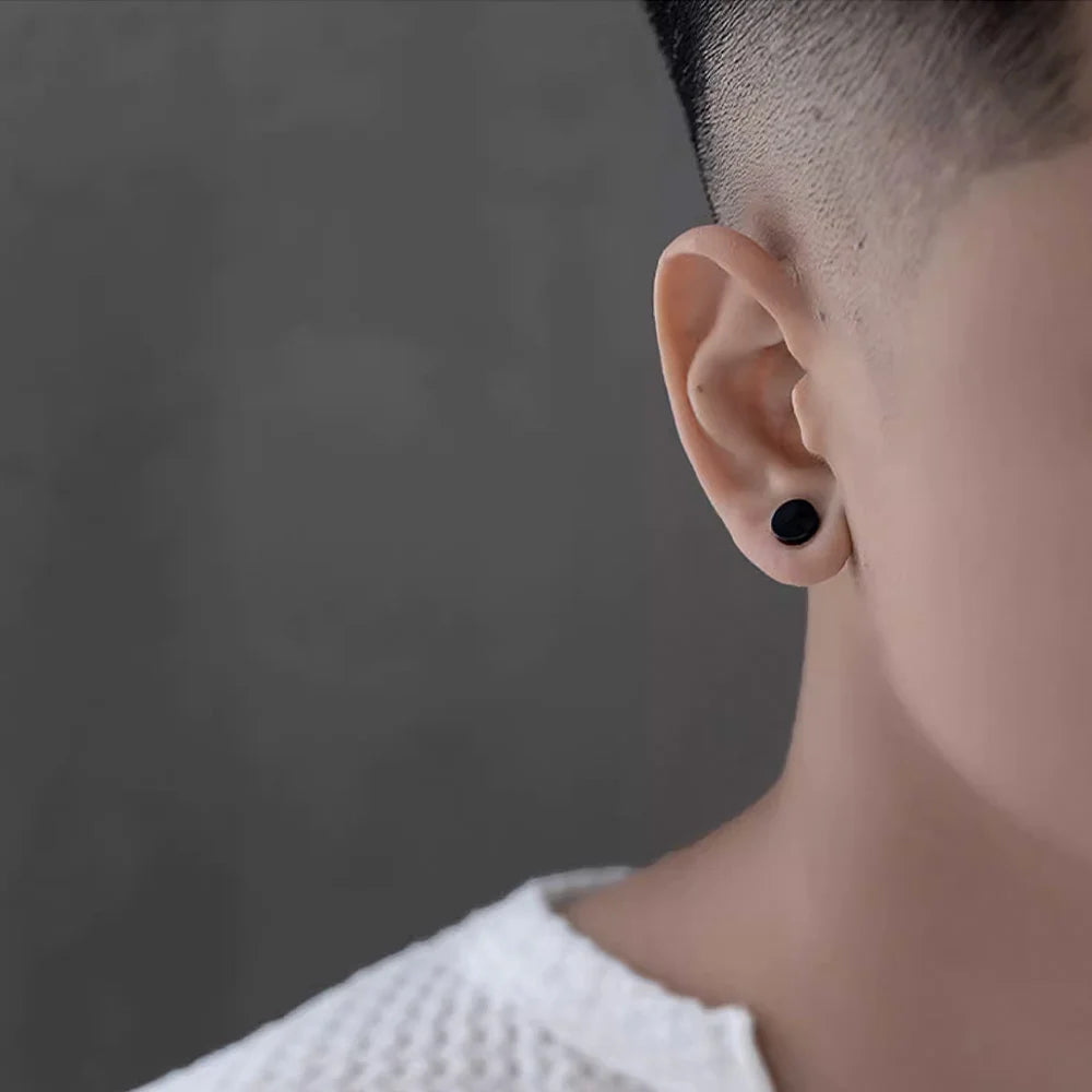 Man wearing a matte black non-piercing magnetic stud earring, showcasing its subtle and stylish look.