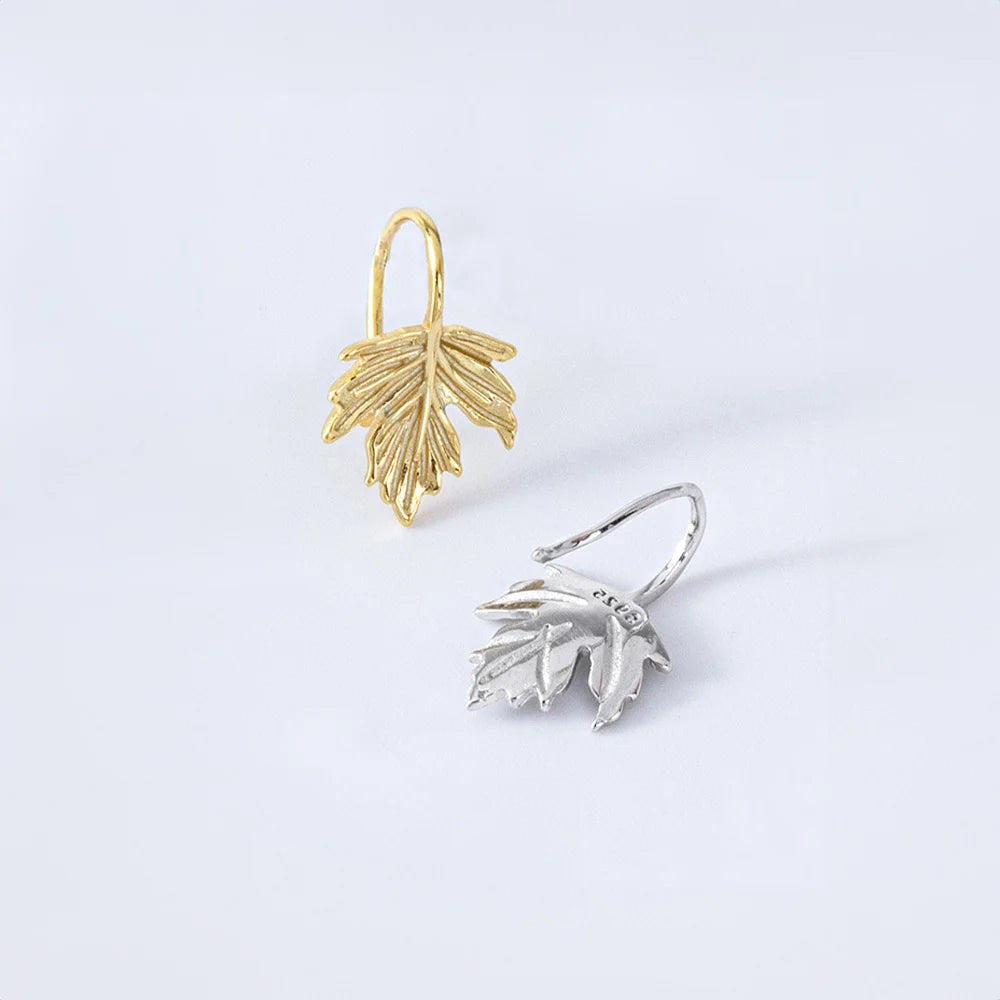 Sterling Silver Maple Leaf Cuff Earrings displayed on a jewelry stand, highlighting their delicate craftsmanship.