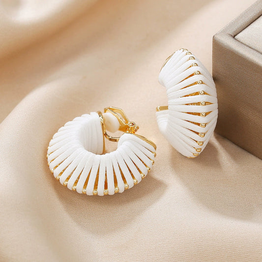 White leather clip-on spiral earrings with gold accents