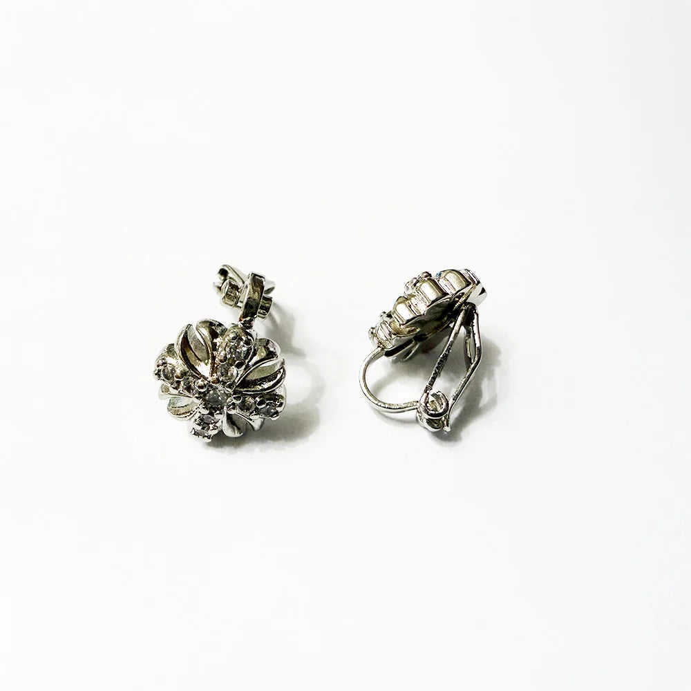 Pair of white gold plated ear studs, cross shaped, on a white background