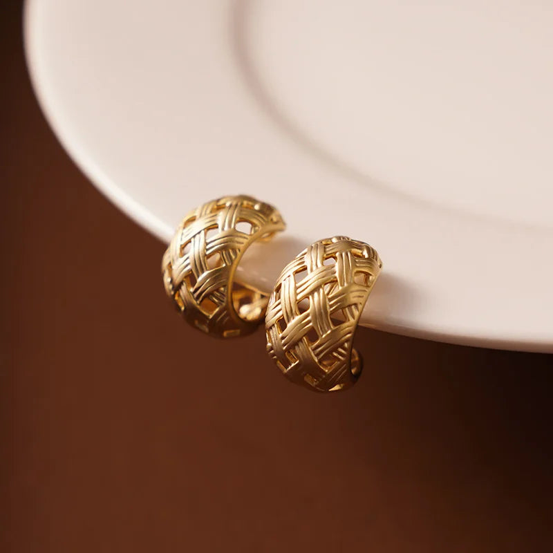 Front view of Woven Crescent Clip-On Hoop Earrings highlighting the bold crescent shape and matte gold finish.