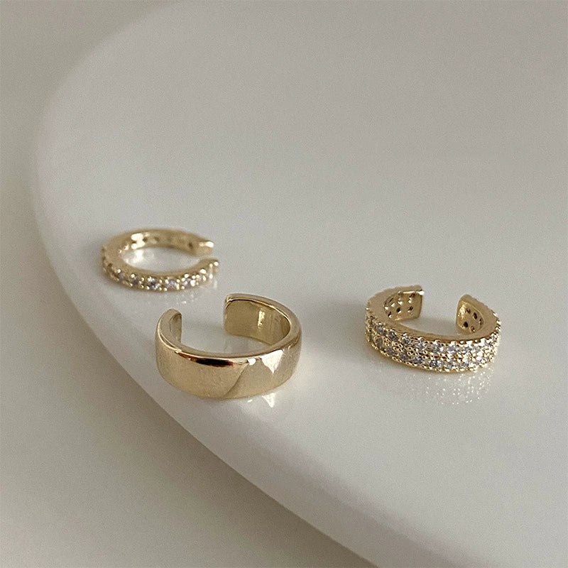 A close-up of the assorted gold cartilage cuff set, highlighting the different textures of the polished and pavé zirconia cuffs.