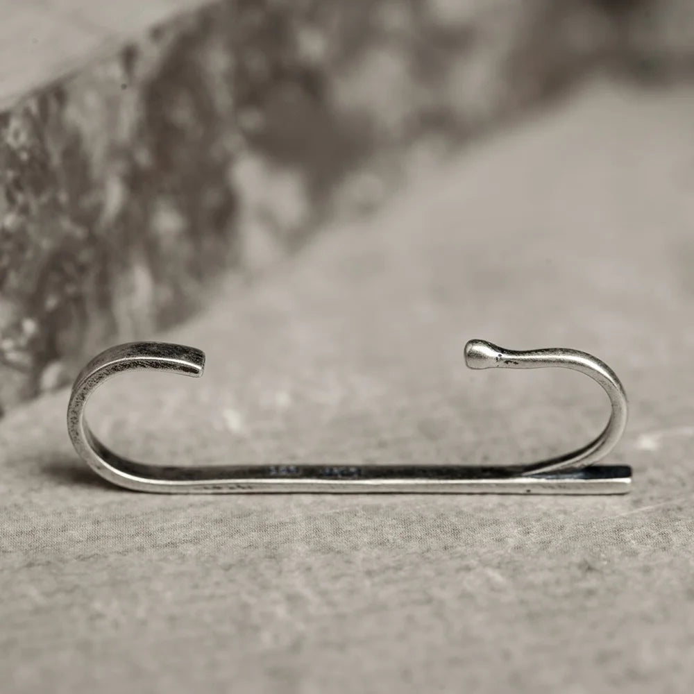 A full profile view of the Axis silver wrap ear cuff, clearly showing the double-hook design that secures it to the ear.