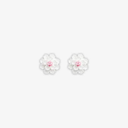 Isolated close-up of two white cluster petal magnetic stud earrings with vibrant pink centers on a clean white background.
