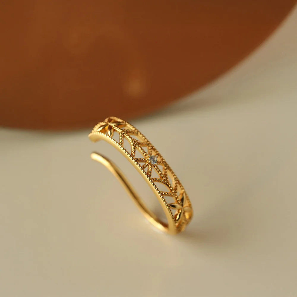 An angled shot of the delicate gold filigree ear cuff, showing the sparkle of the central crystal accent.