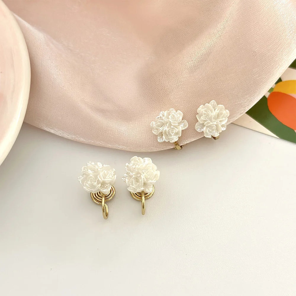 A pair of white flower clip-on studs earrings
