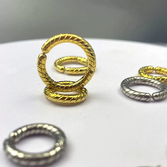 Two gold twisted rope clip-on hoop earrings interlinked, showcasing the seamless spring closure and textured detail.