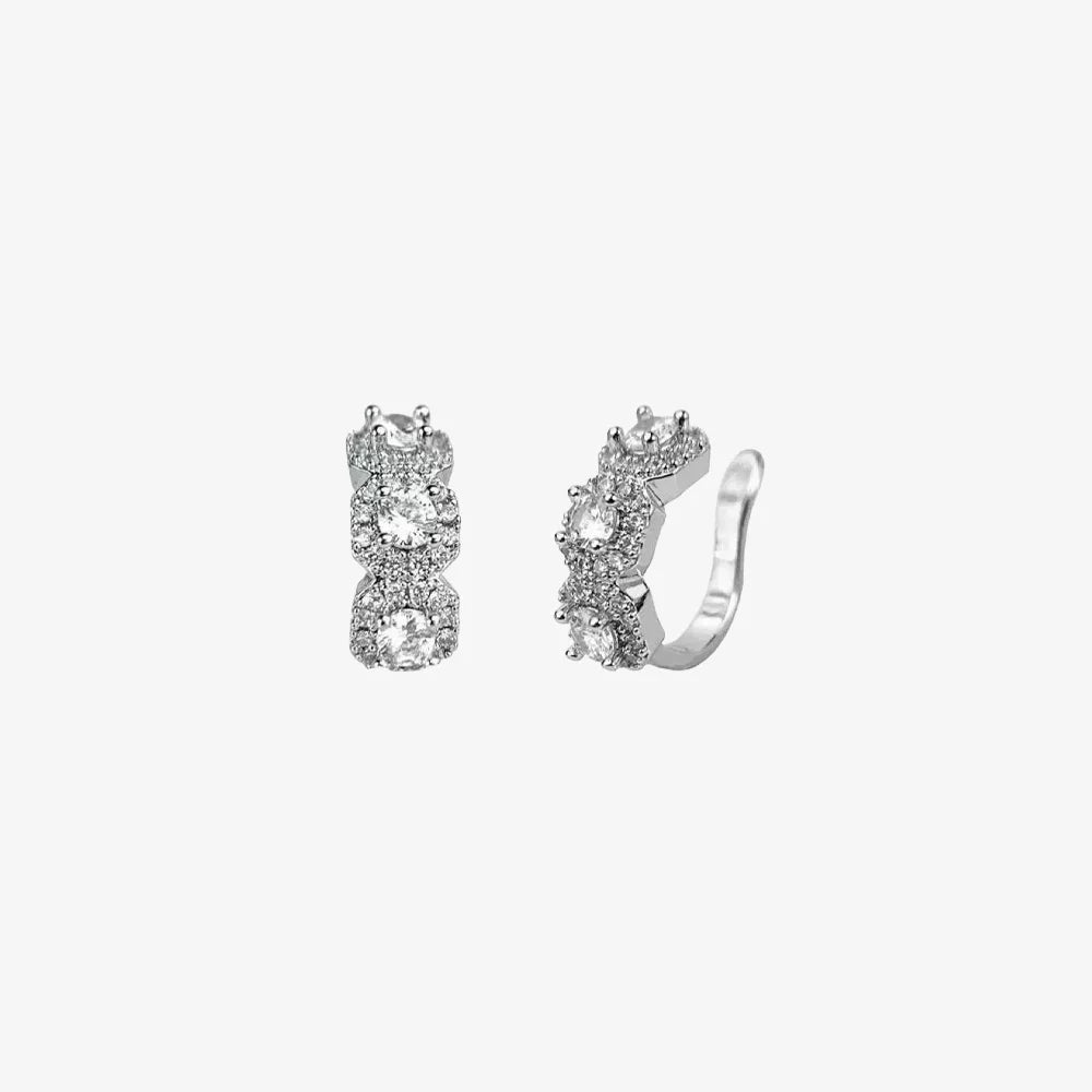 A studio shot of a pair of Halo Nova silver triple zircon pavé clip-on ear cuffs on a clean white background,