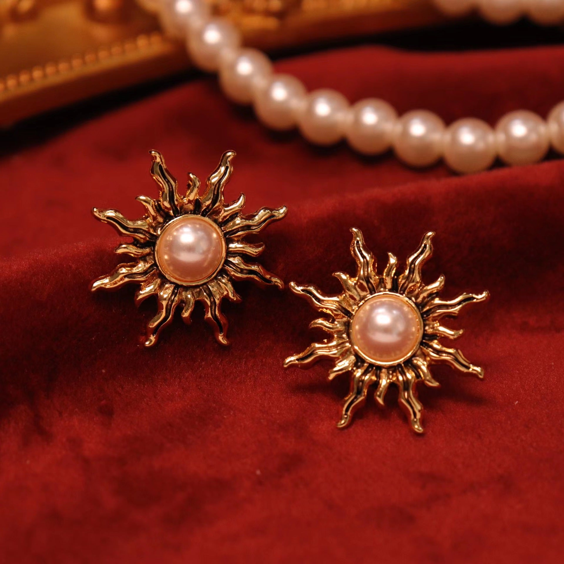 Sparkle like the stars with these charming gold sunburst clip-on earrings.  Adorned with luminous faux pearls, they capture the essence of the celestial trend.  The secure hinged back closure ensures a comfortable fit for non-pierced ears.
