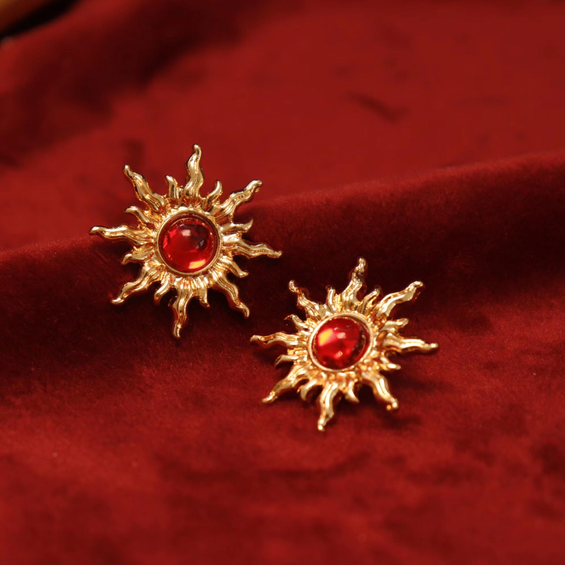 Gold sun clip-on earrings with fiery red gems. Hinged back for non-pierced ears. Embrace the celestial trend. celestial jewelry.