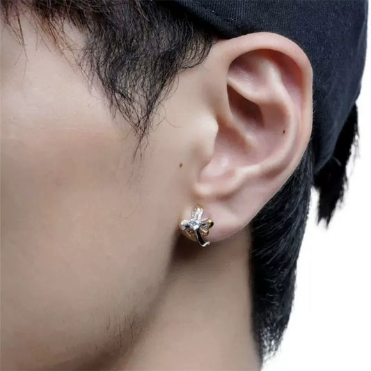 Close-up of a person wearing the Regal Two-Tone Cross Clip On Earring, showing how it sits comfortably on a non-pierced earlobe.