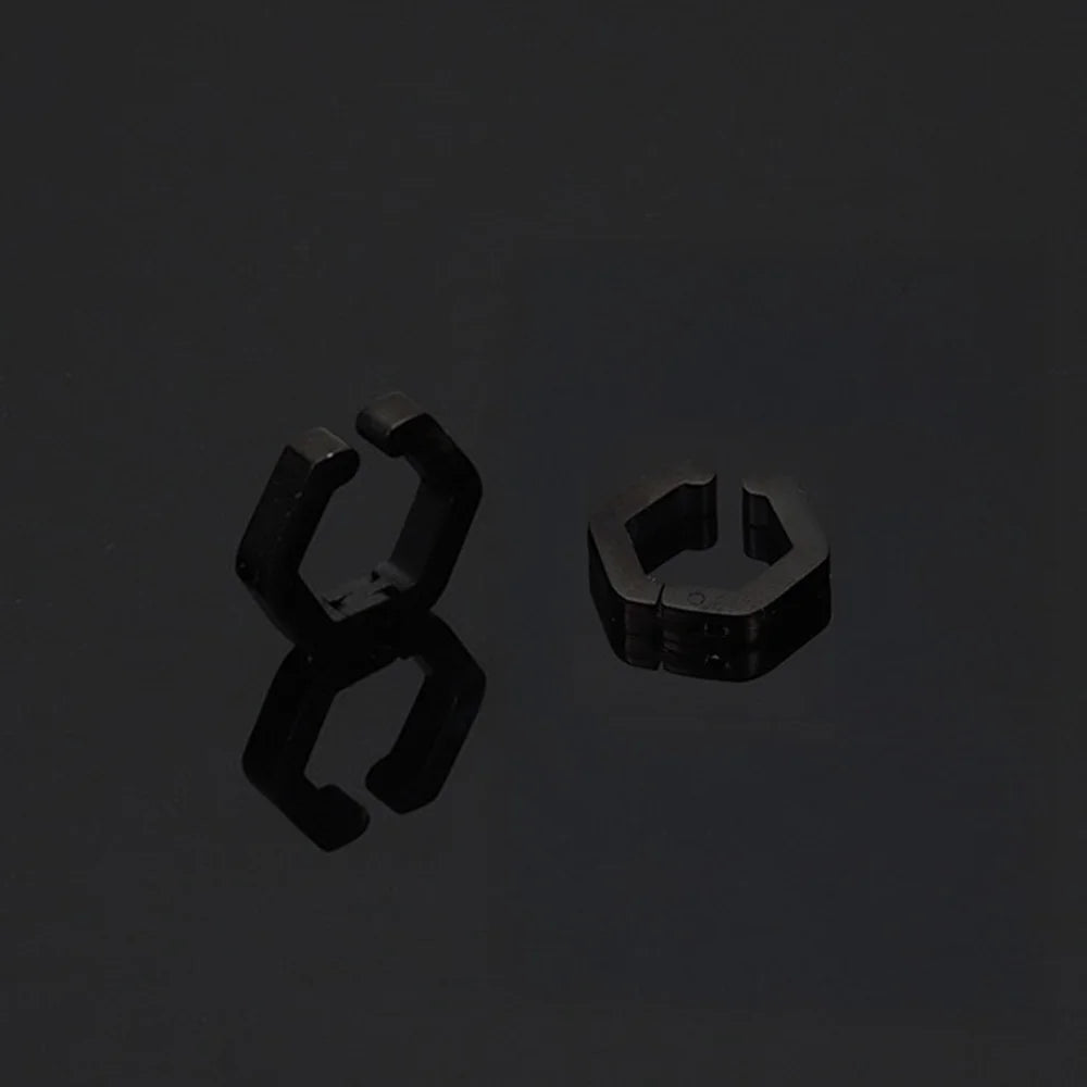 A stylish product shot of the men's titanium steel clip-on huggie earrings on a reflective black surface.