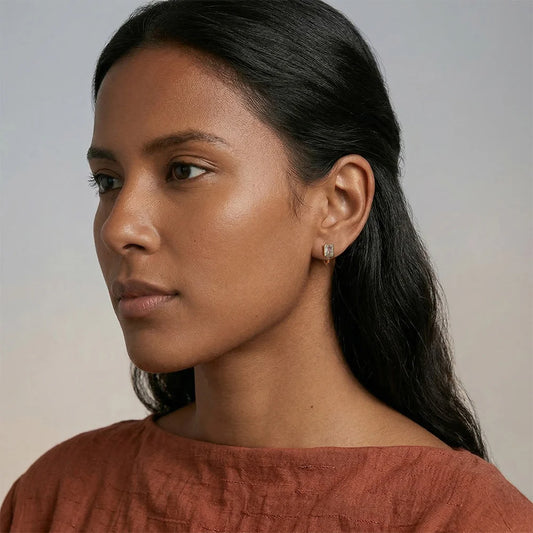 A fashion model wearing vintage-inspired gold clip-on earrings, showcasing the elegant fit and brilliant sparkle for bridal or evening wear.