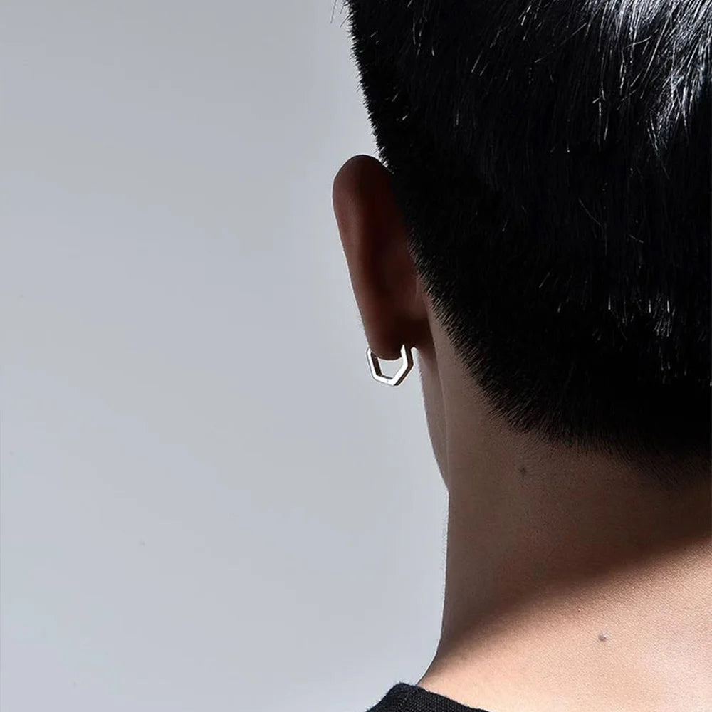 A back-of-the-head view of a model wearing the silver hexagon clip-on earring, showing its clean and subtle profile.