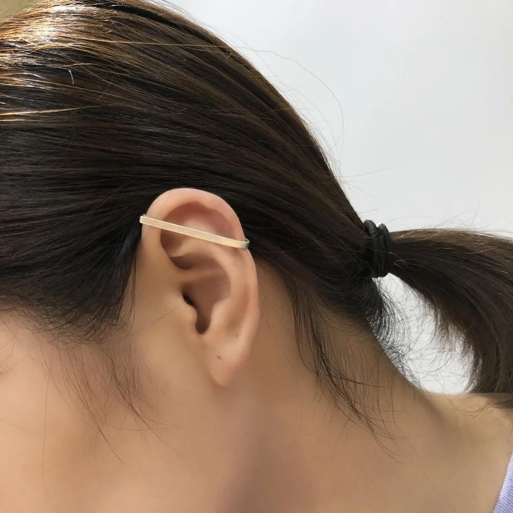 A model showcases the Axis sterling silver wrap ear cuff on her ear, demonstrating how it fits comfortably.