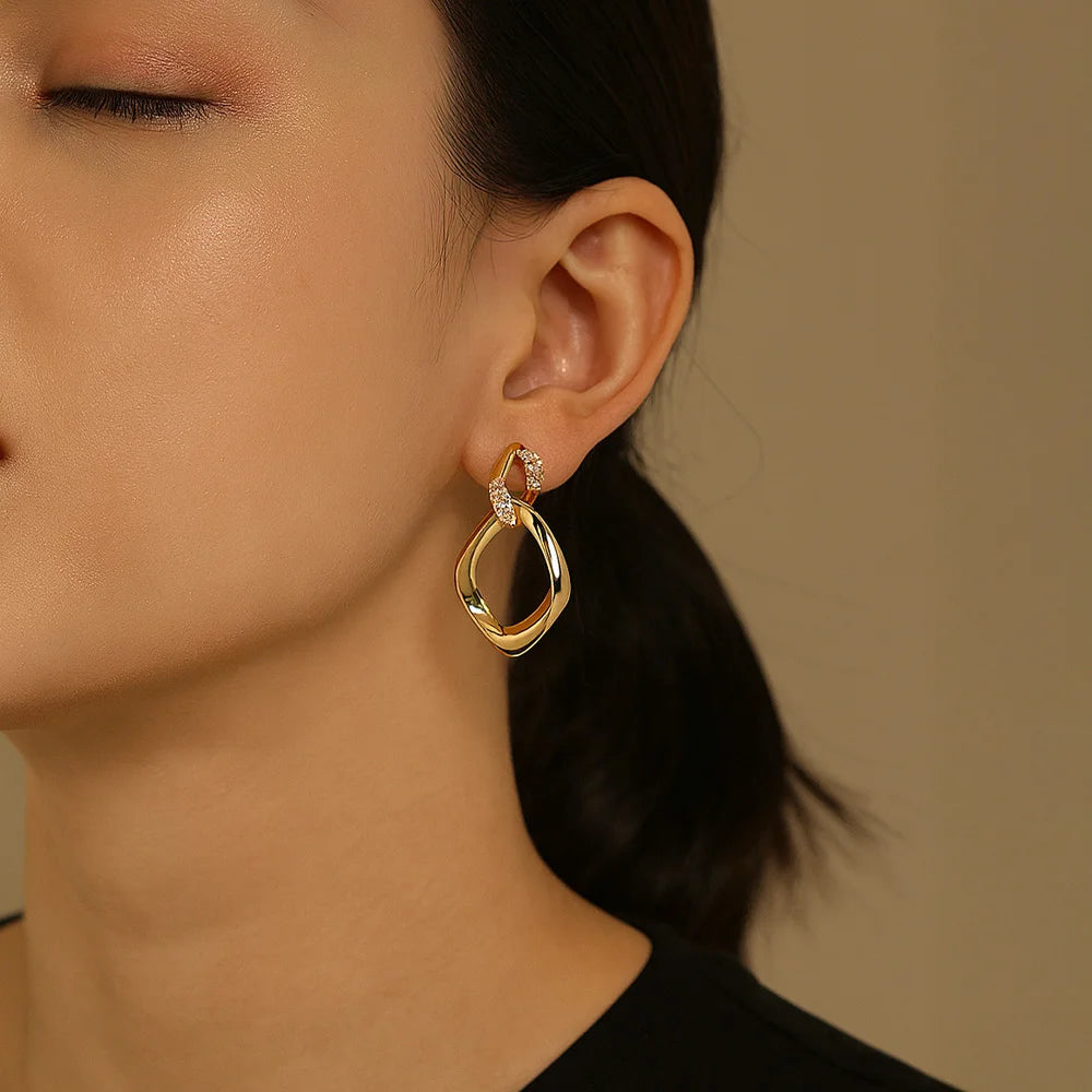 A model wearing the gold geometric rhombus clip-on earrings to showcase their dangle length and how they look on non-pierced ears.