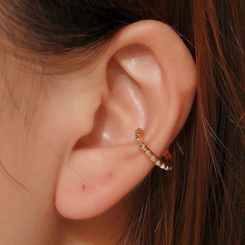 Close-up of a model's ear wearing the gold studded sterling silver ear cuff on her conch for a bold, edgy look.