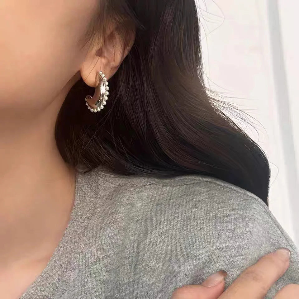 A model wearing the Luna pearl crescent clip-on earring, showcasing its size and elegant look on the ear.