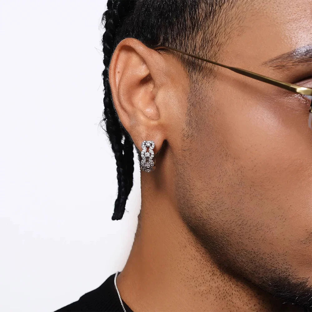 A male model wearing the Luxe Iced Out Pavé Wave Clip-On Hoop Earring, showcasing its size and brilliant moissanite shine on the ear.
