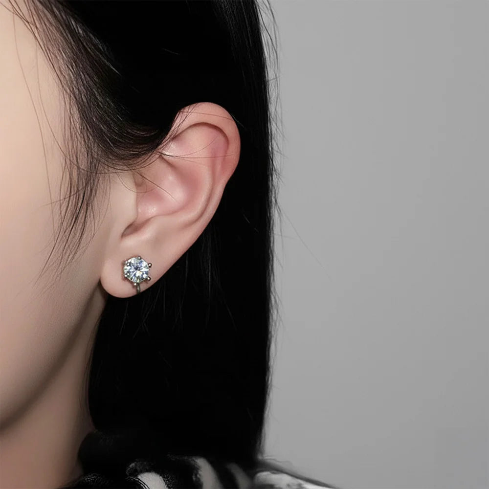 A model wearing a single silver solitaire clip-on stud earring with a round cubic zirconia stone on her earlobe, demonstrating the non-pierced design.