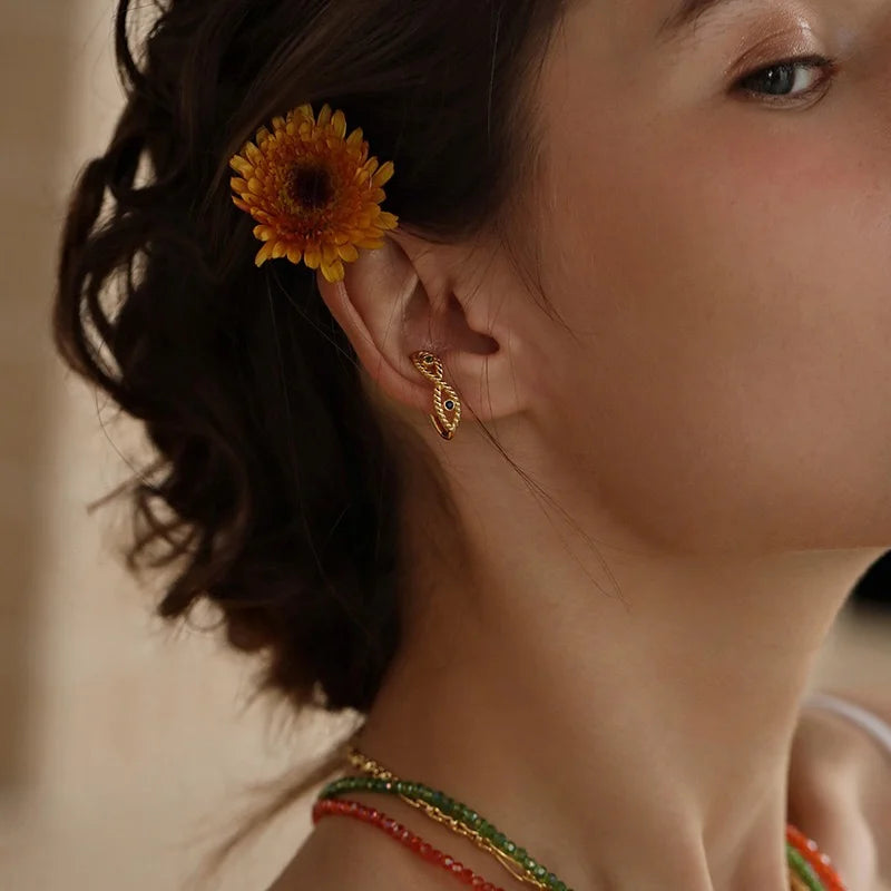 Model wearing the Serpentine twisted rope and gemstone gold ear cuff on her lobe.