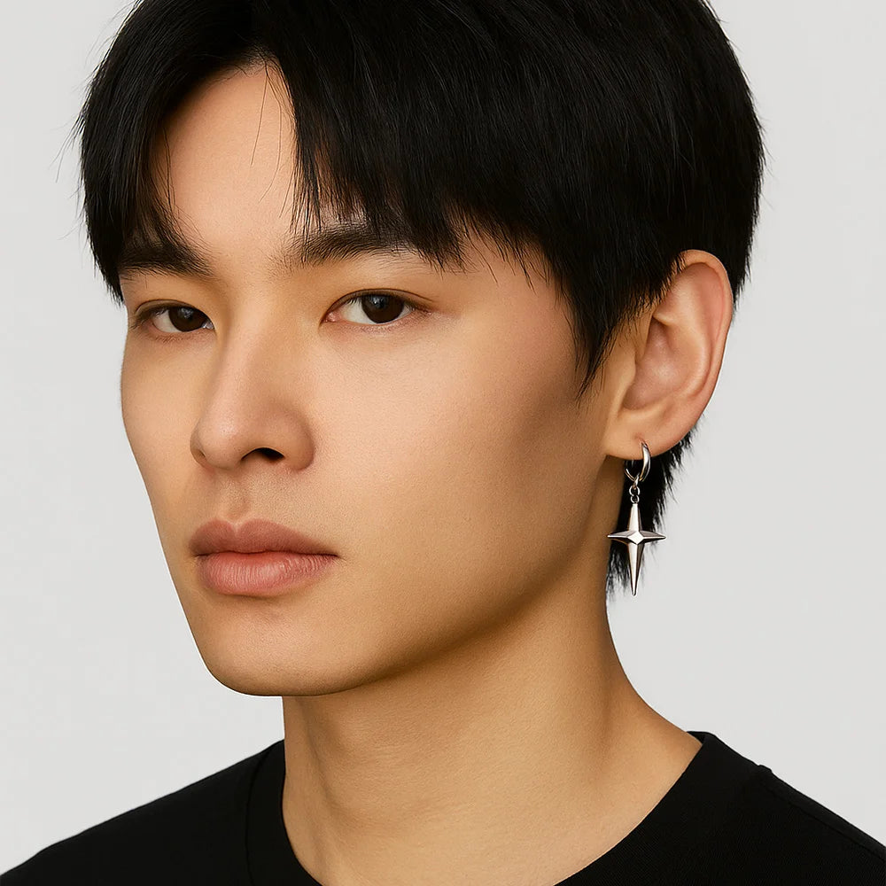 A male model with short dark hair wearing silver polaris star clip-on hoop earrings, showcasing kpop style.