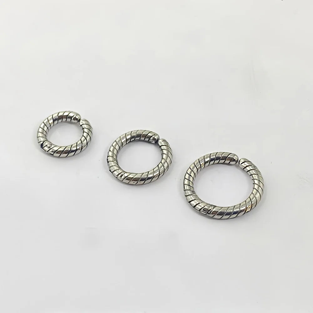 Three different sizes of the twisted silver clip-on hoop earrings, perfect for creating a stacked cartilage look.