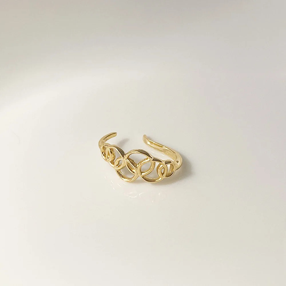 A detailed product shot of the gold lobe cuff, highlighting the openwork pattern of linked circles.