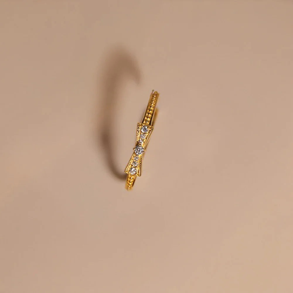 A top-down view of the gold ear cuff, highlighting the sparkling pave crystals on the bow detail.