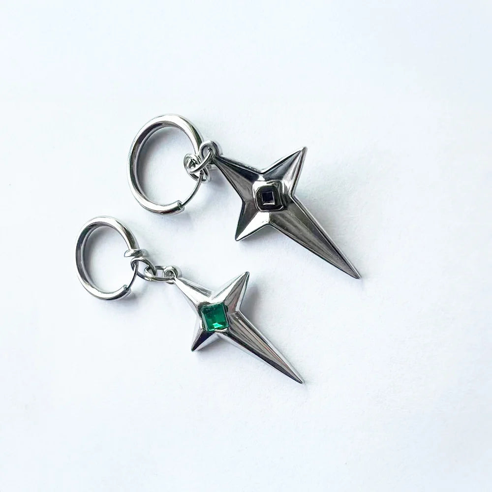 Pair of polaris star clip-on earrings on a white surface, one showing the front view with a green gem and the other showing the back view of the green gem version.