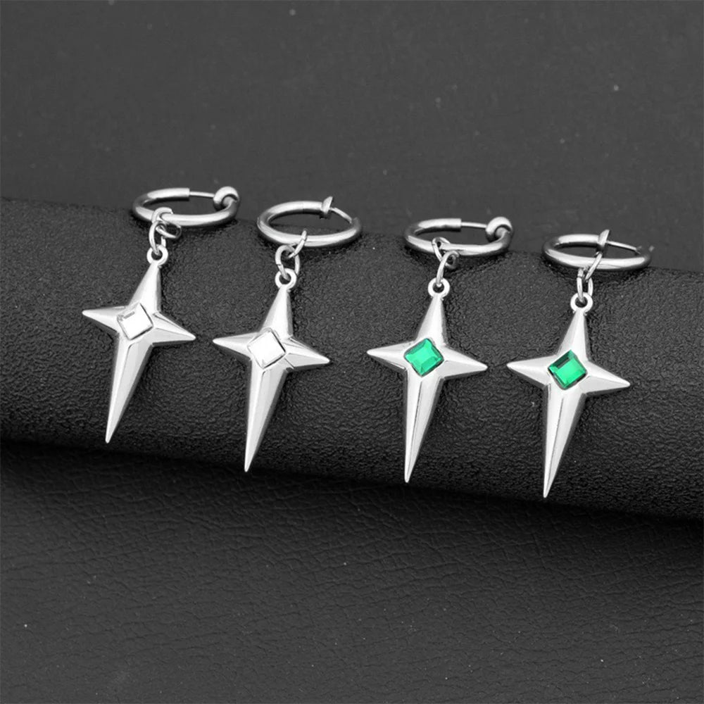 Two pairs of silver polaris star clip-on hoop earrings, one pair with a green gem and one with a white gem, displayed on a black surface.