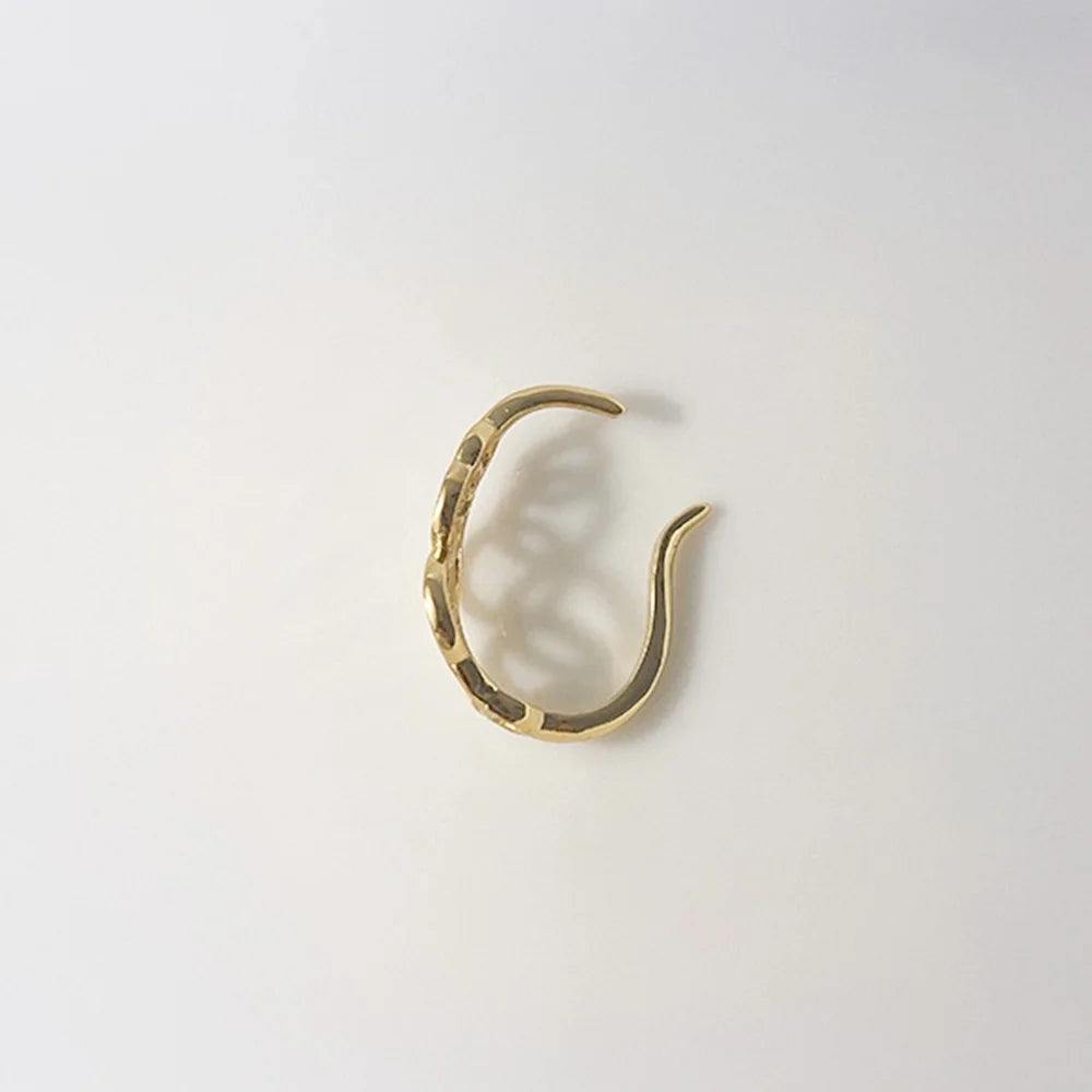 A side view of the geometric gold lobe cuff, showing the C-shape that wraps around the earlobe.