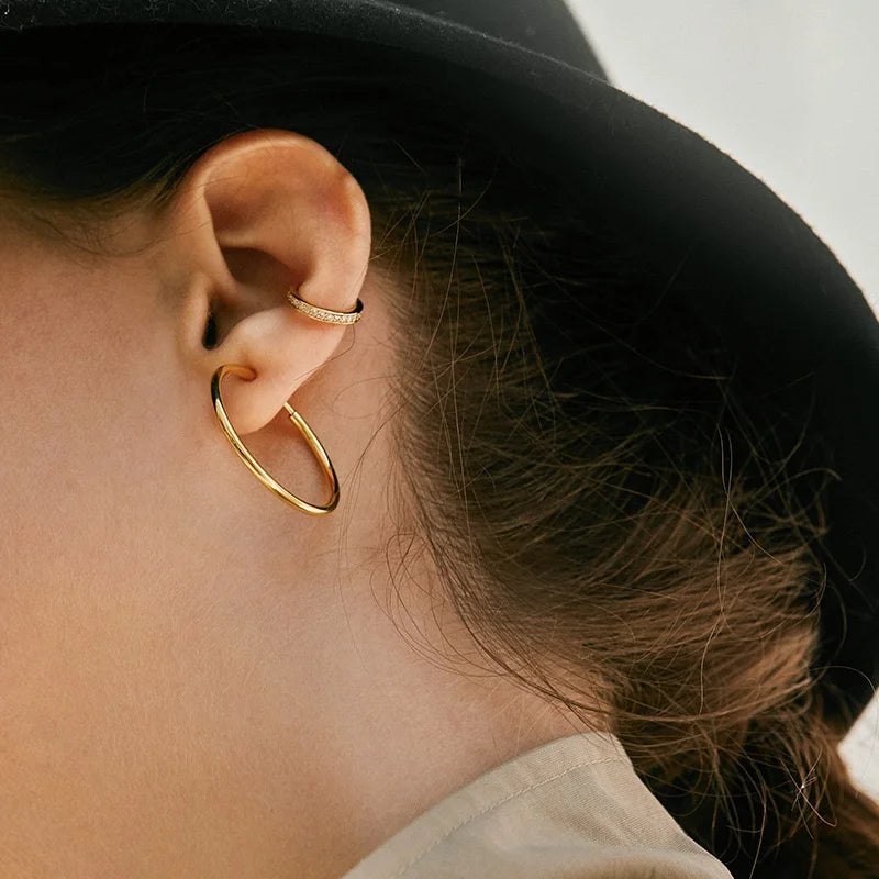 A model showcasing a stacked ear look, featuring the pavé gold non-pierced cuff on her upper cartilage.