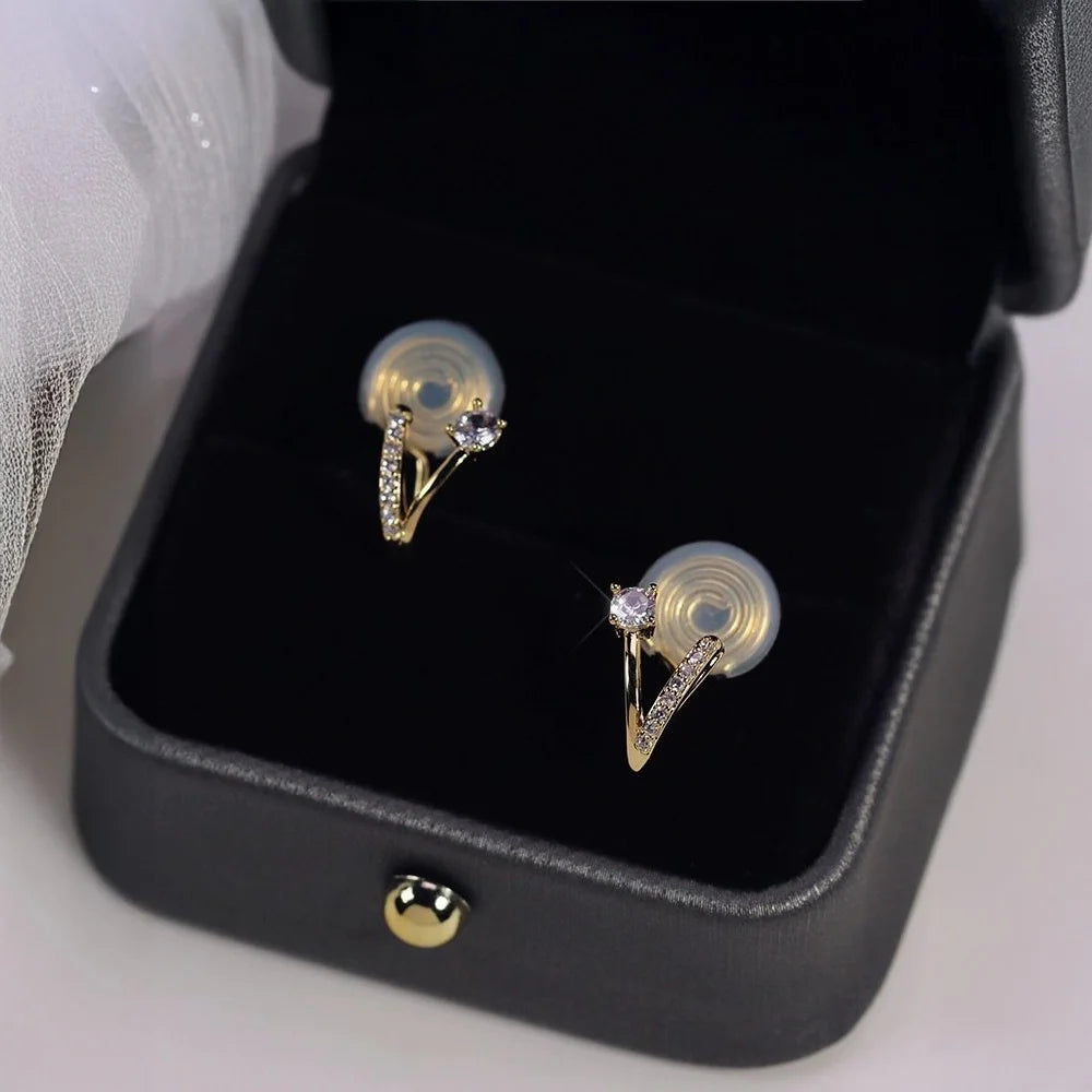 Detail of unique 18K gold plated clip-on earrings showing brilliant zircon stone and pavé crystal ribbon