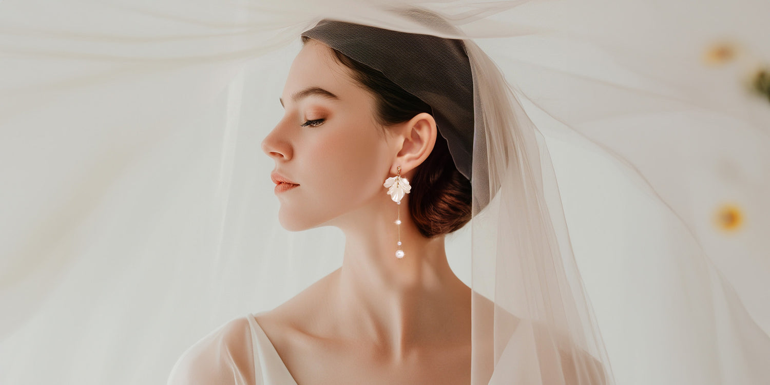 A bride wearing these Floral Pearl Clip Earrings on her wedding day. The design features delicate white flowers descending into a faux pearl drop. 