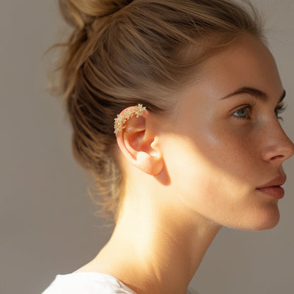 Profile view of a woman model showcasing a warm gold Blossom Flower Crystal Helix Ear Cuff, adorned with shimmering zircon gems, elegantly curved around her ear for a sophisticated bridal look.