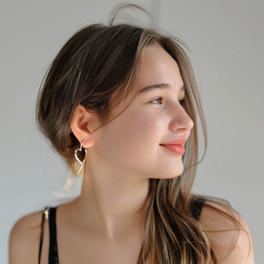 Girl wearing gold minimalist heart clip-on earrings. Perfect for Valentine's Day or a touch of everyday cottagecore charm. Secure coil closure for comfort. 