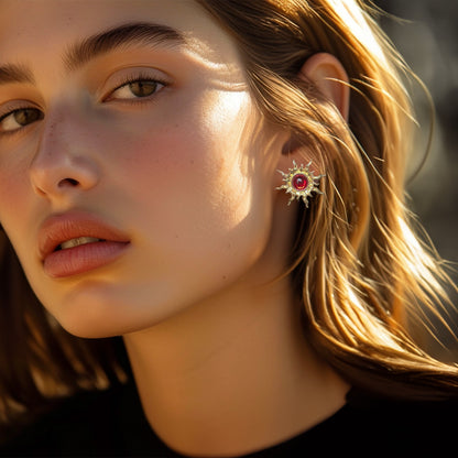 Channel your inner power with these dazzling gold sun clip-on earrings.  Set with fiery red faux rubies, these celestial-inspired earrings are perfect for adding a touch of bold style.  The secure hinged back closure ensures a comfortable fit for non-pierced ears.