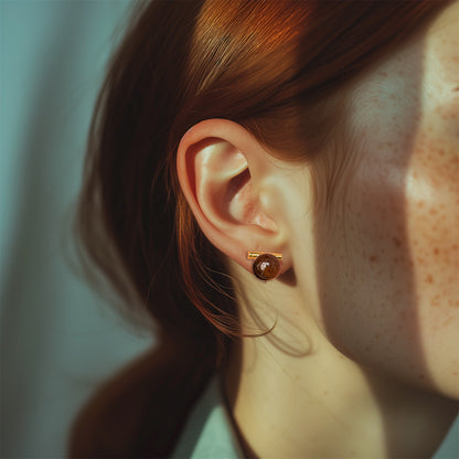 Side profile of a woman wearing modern tiger's eye clip-on earrings, showcasing the warm brown resin and alloy construction with a vintage touch, secured with a coil clip-on.