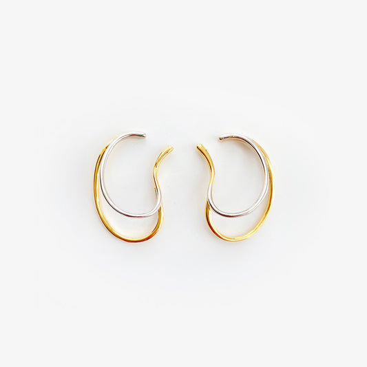 Gold and silver toned Dual-Tone Wave Conch Ear Cuffs on a stark white background, embodying a modern design ideal for a minimalist yet elegant daily accessory, no piercing needed.