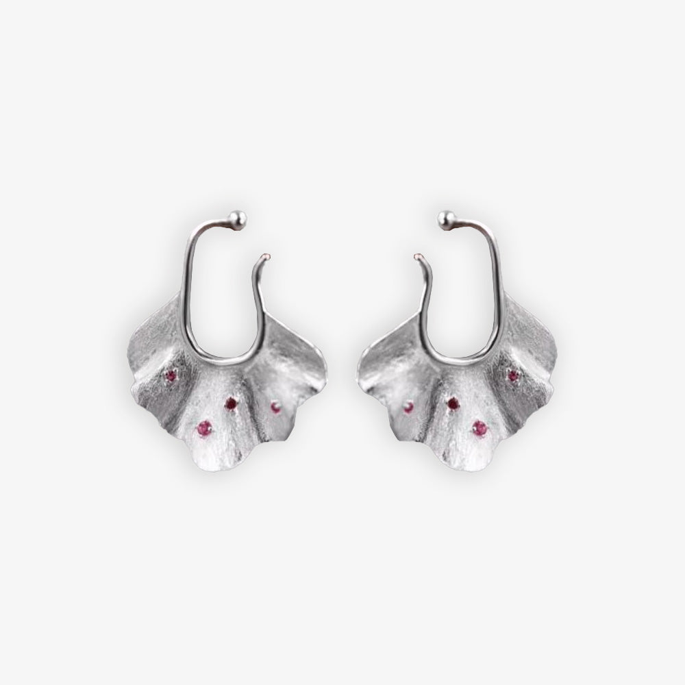 Pair of silver Ginkgo Leaf Ear Conch Cuff Earrings with cherry red zircon accents displayed on a white background, symbolizing nature's eternal elegance and perfect for adding a botanical touch to any outfit.