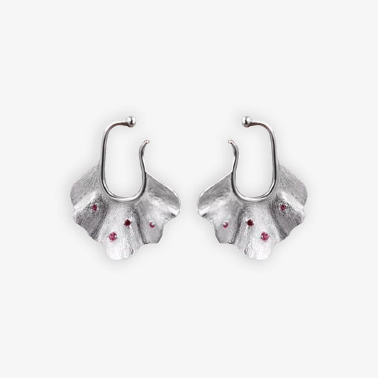 Pair of silver Ginkgo Leaf Ear Conch Cuff Earrings with cherry red zircon accents displayed on a white background, symbolizing nature's eternal elegance and perfect for adding a botanical touch to any outfit.