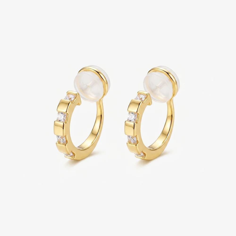 A pair of 16k yellow gold finished huggie clip on earrings with sparkling baguette cubic zirconia in a lattice setting.