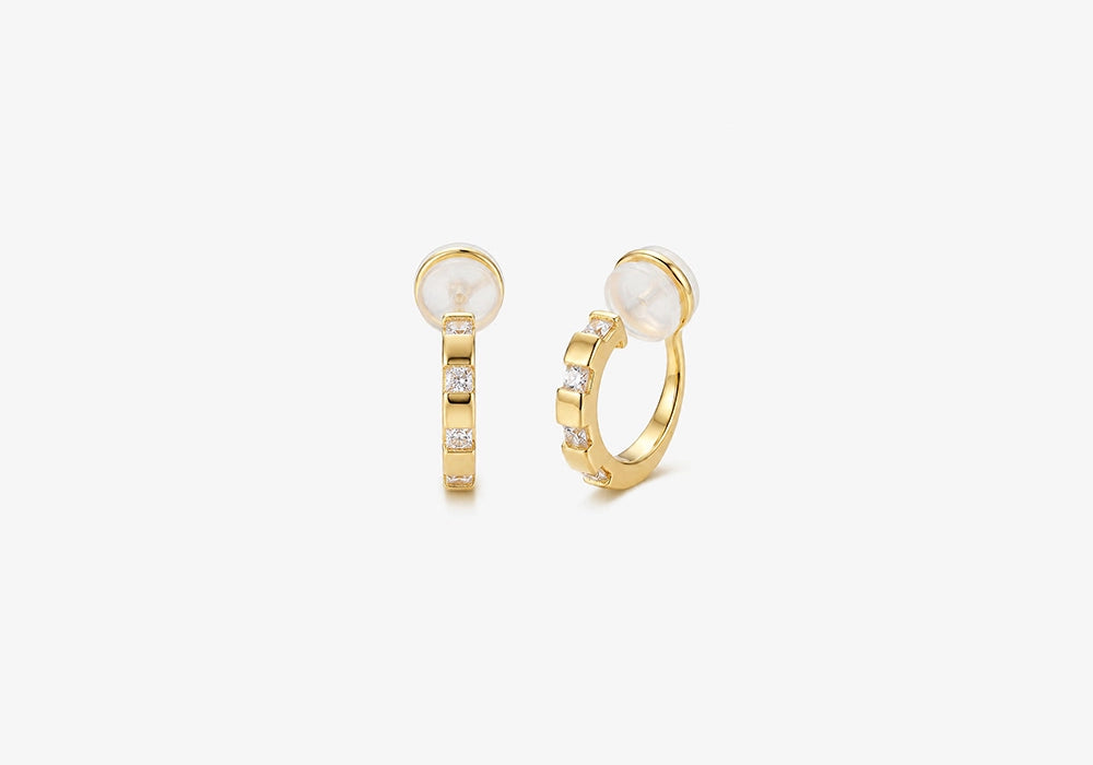A pair of 16k yellow gold finished huggie clip on earrings with sparkling baguette cubic zirconia in a lattice setting.
