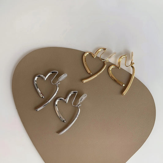 Delicate golden or silver heart clip-on earrings for a touch of understated romance. The minimalist design adds a touch of elegance to any outfit. Made from alloy with a comfortable coil clip closure, they're perfect for everyday wear. 