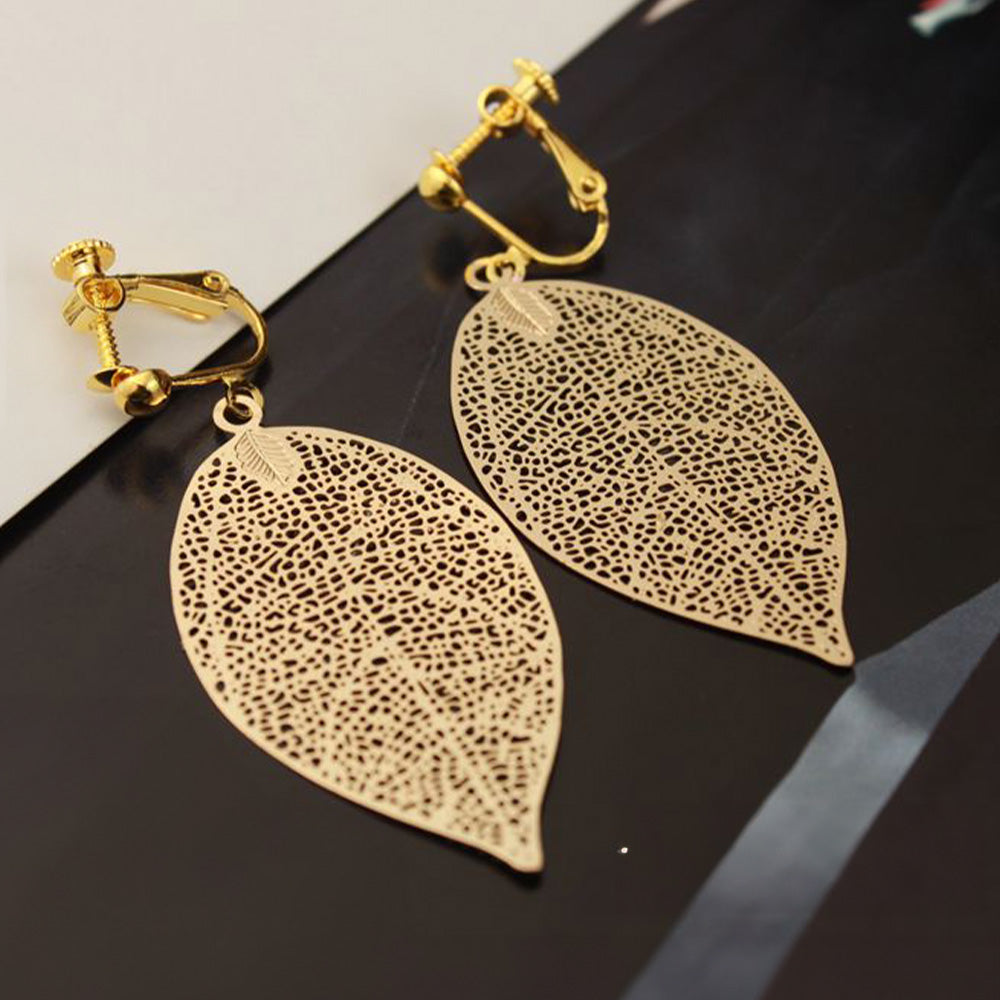 Nature-inspired gold leaf dangle earrings with a secure screw-back clip-on mechanism, crafted in a shining gold tone copper alloy for a modern aesthetic.