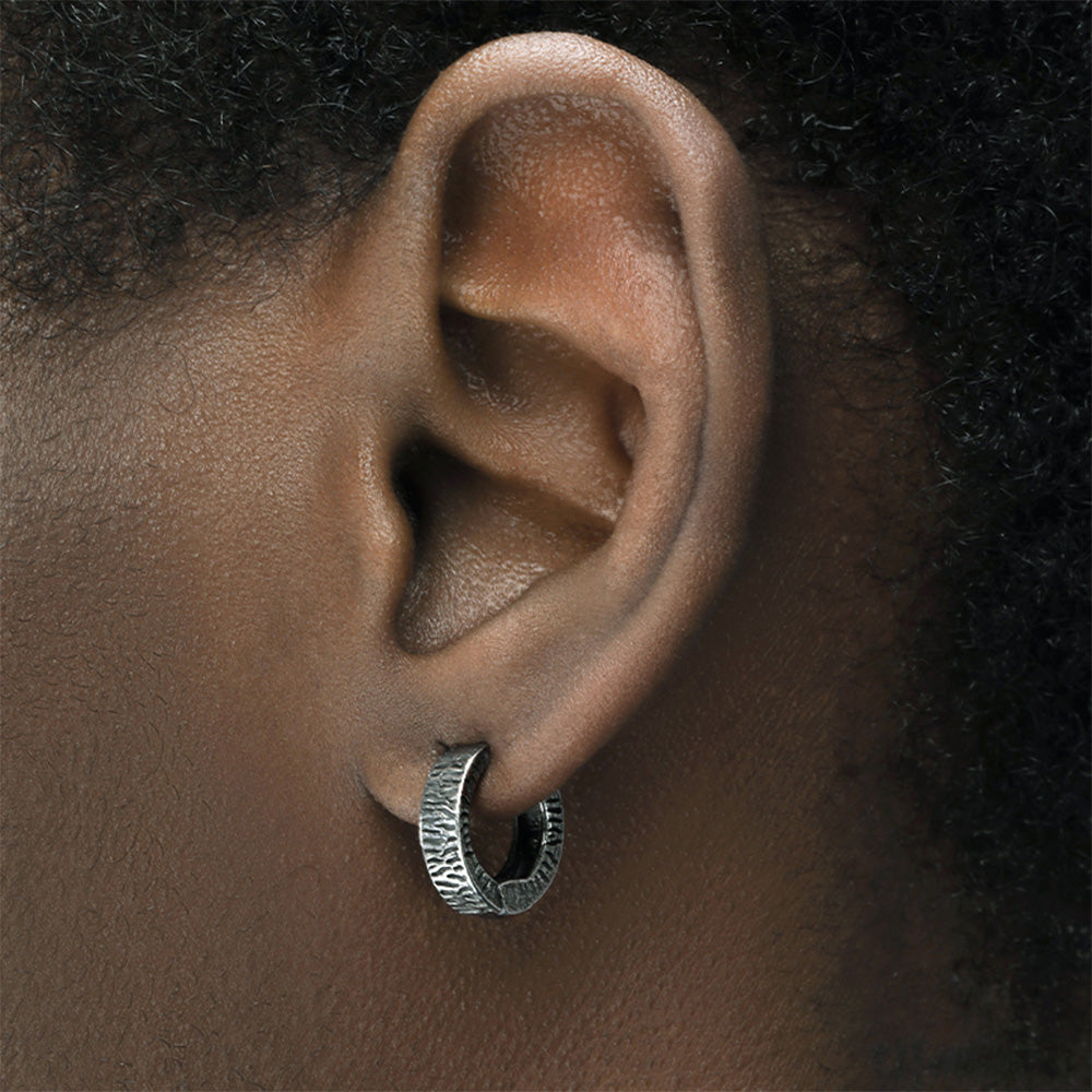 Dark gray Vintage Tyre Clip-On Earrings crafted from durable titanium steel with a textured tire tread design. Hinge-back clip-ons offer comfortable wear, perfect for men's fashion. Ideal for those who appreciate vintage style with an industrial edge, these earrings are versatile for casual or statement looks.